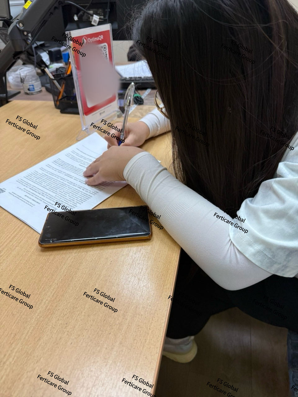 Filling in and signing the document at a desk.